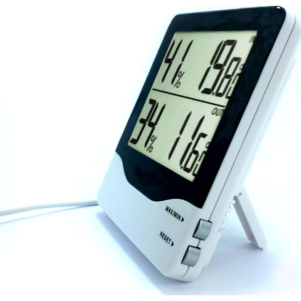 Ein weißer Digitalthermometer mit einem schwarzen Bildschirm, der Innen- und Außentemperaturen anzeigt.