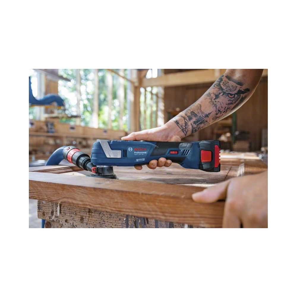 Un artigiano usa uno strumento oscillante blu Bosch su un pezzo di legno.