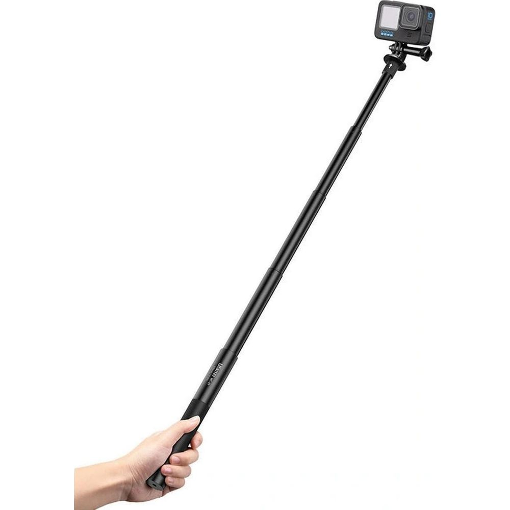 Dłoń trzyma czarny kijek do selfie z kamerą GoPro na końcu.