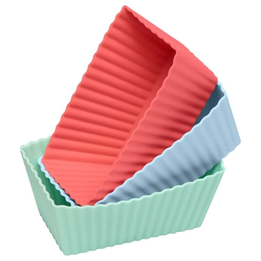 Trzy prążkowane silikonowe formy do pieczenia w kolorze czerwonym, jasnoniebieskim i miętowym ułożone jeden na drugim.