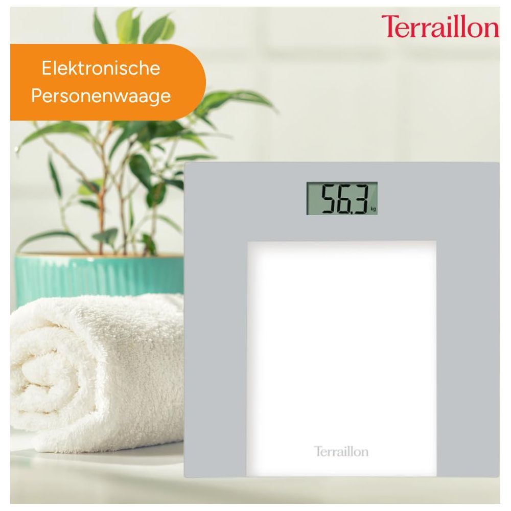 Szara waga cyfrowa pokazuje 56,3 kg, obok zwiniętego białego ręcznika.