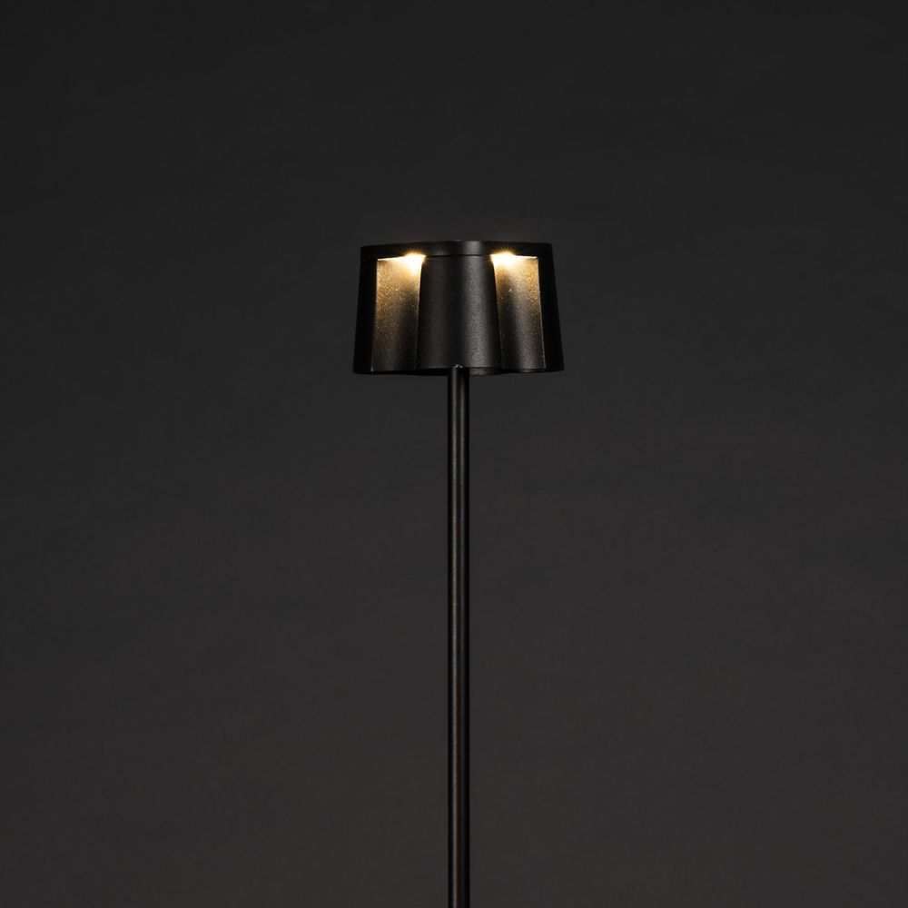 Eine moderne schwarze Stehlampe mit drei Lichtquellen, die nach unten leuchten.