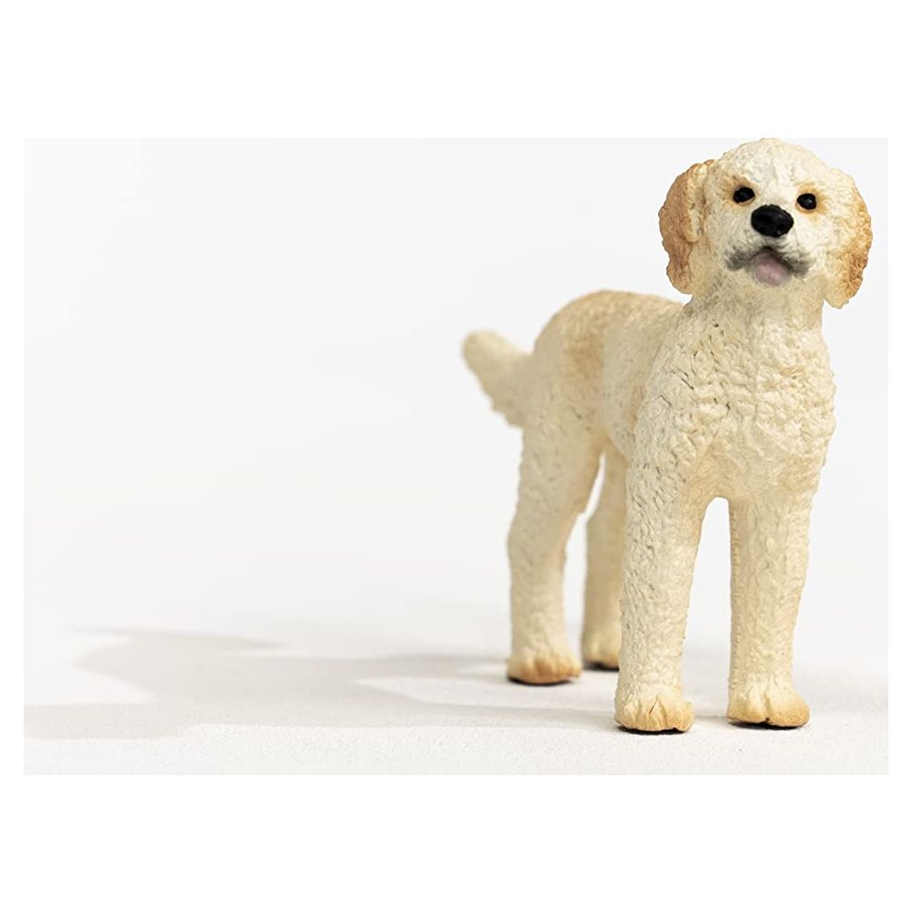 Statua di cane color crema su sfondo bianco con ombra.