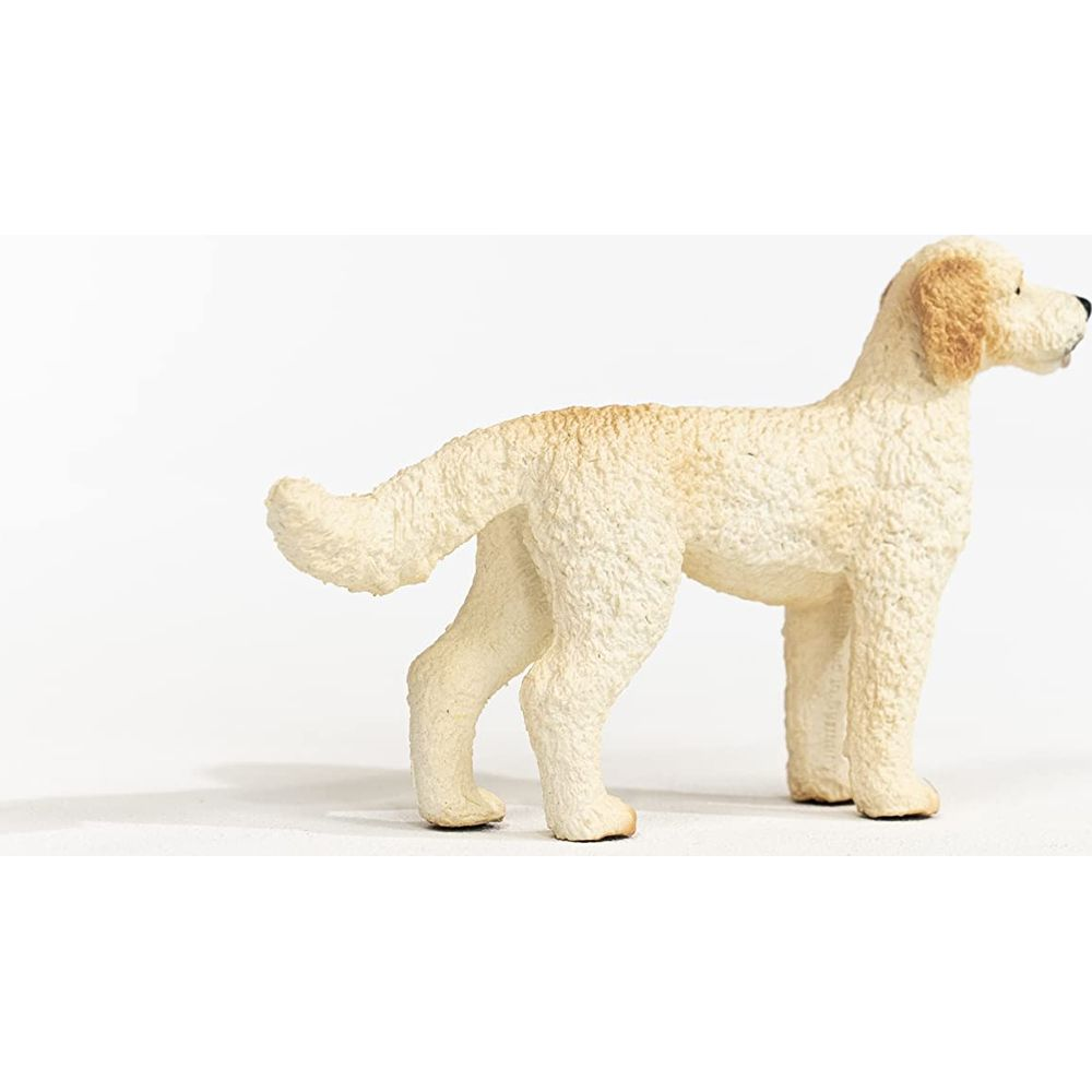 Statua di cane color crema con pelo riccio su sfondo bianco.