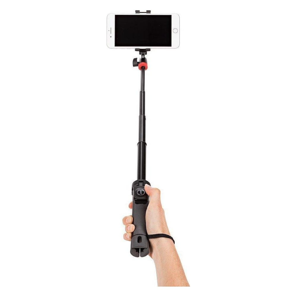 Una mano tiene un selfie stick nero con uno smartphone bianco.