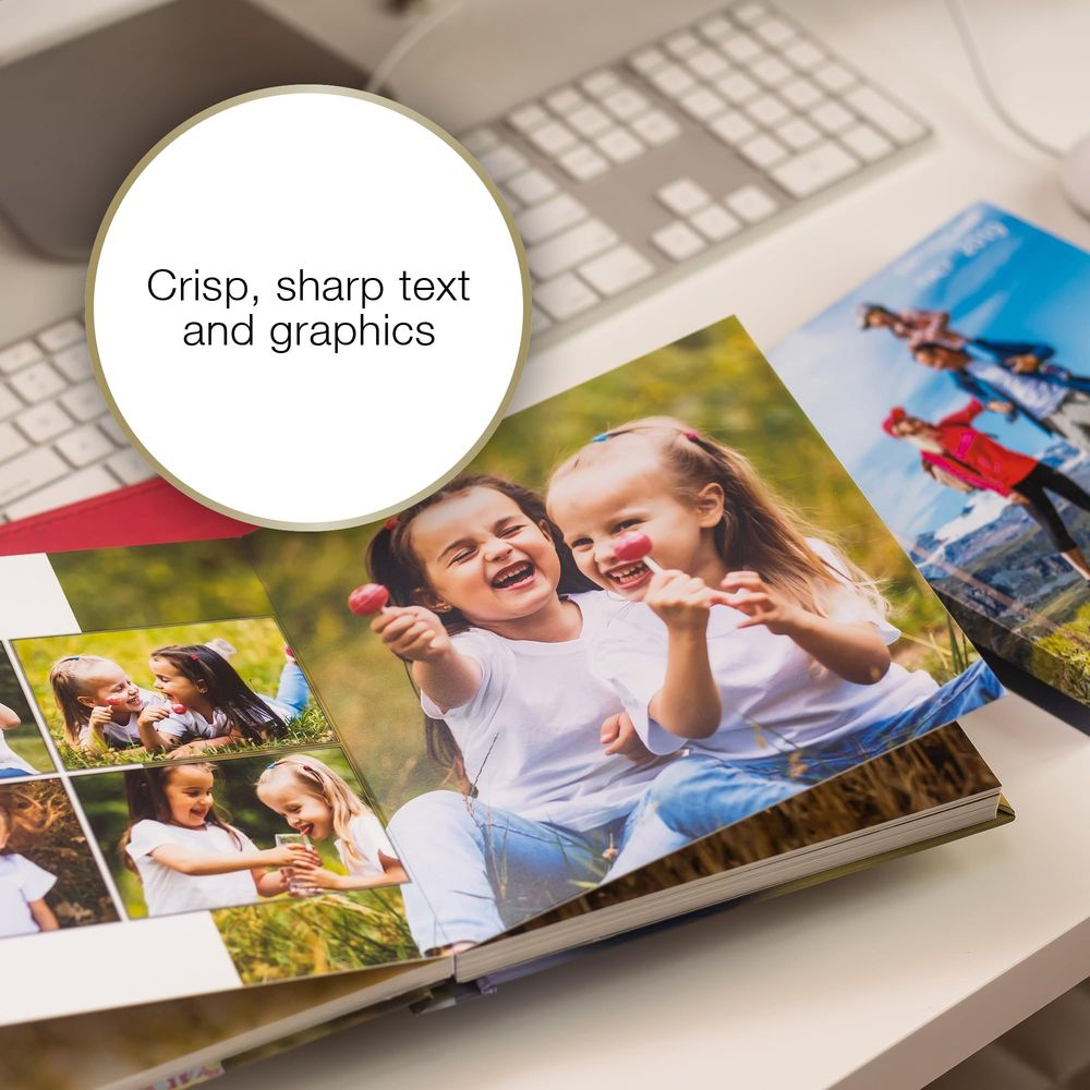 Dwie śmiejące się dziewczynki w albumie fotograficznym, z klawiaturą w tle.