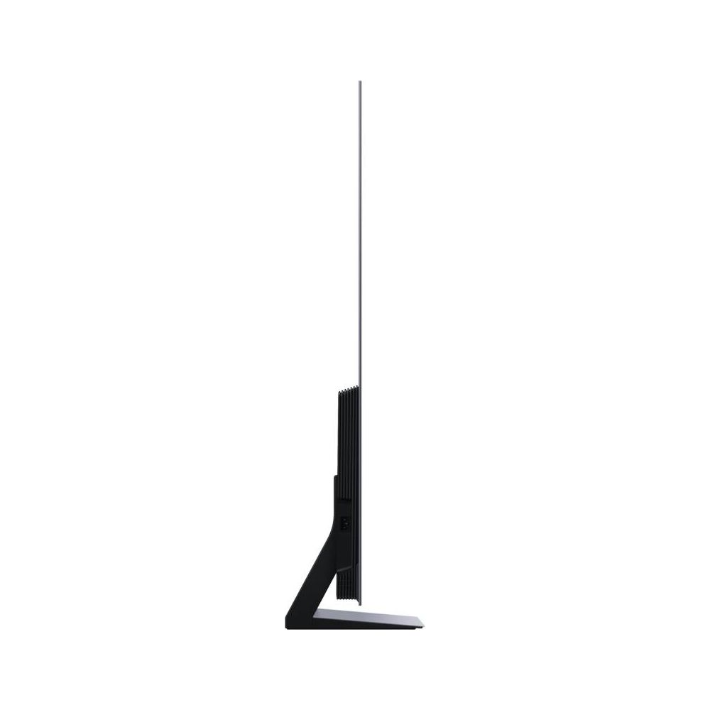 Un téléviseur noir avec un pied étroit sur fond blanc, vu de côté.