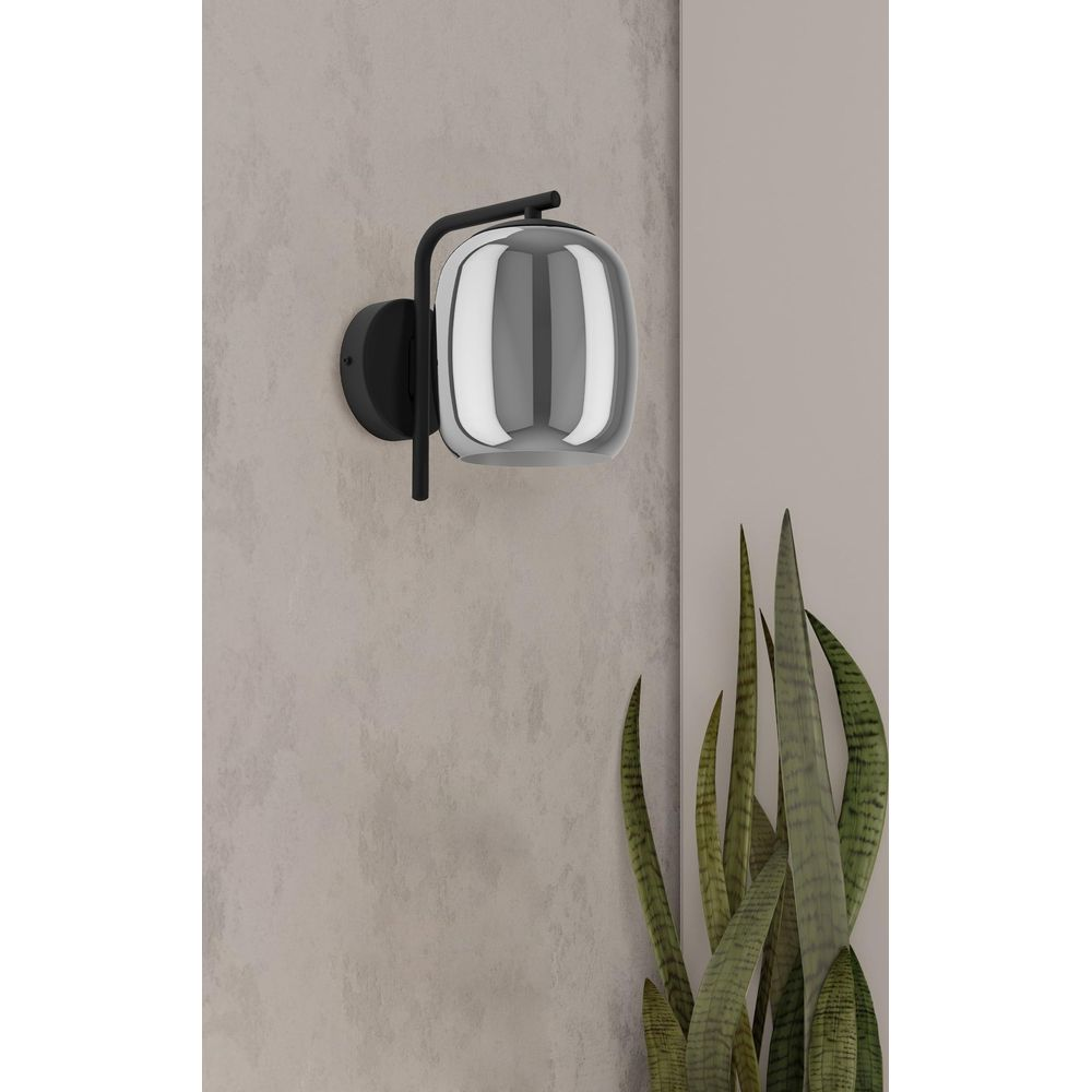 Moderne Wandleuchte mit grauem Glas und schwarzem Metallgestell.