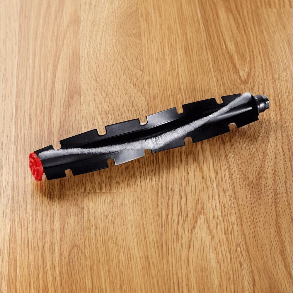 Testina spazzola nera con accenti rossi su superficie in legno.