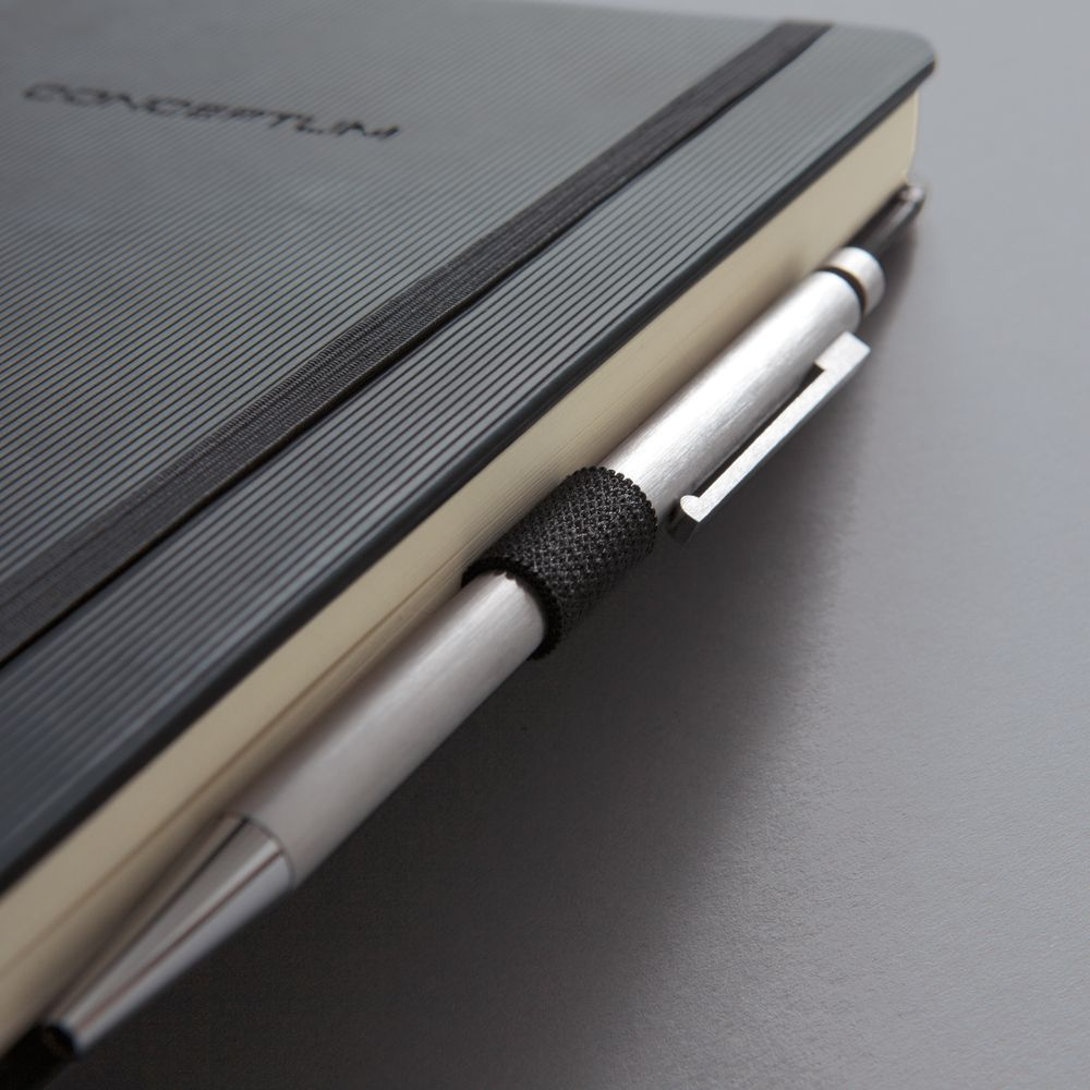 Ein silberner Stift steckt in einem schwarzen Notizbuch mit Gummiband.