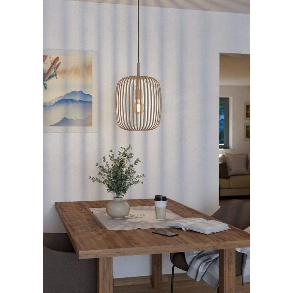 Een eettafel met een lamp, een vaas met planten en een boek erop.
