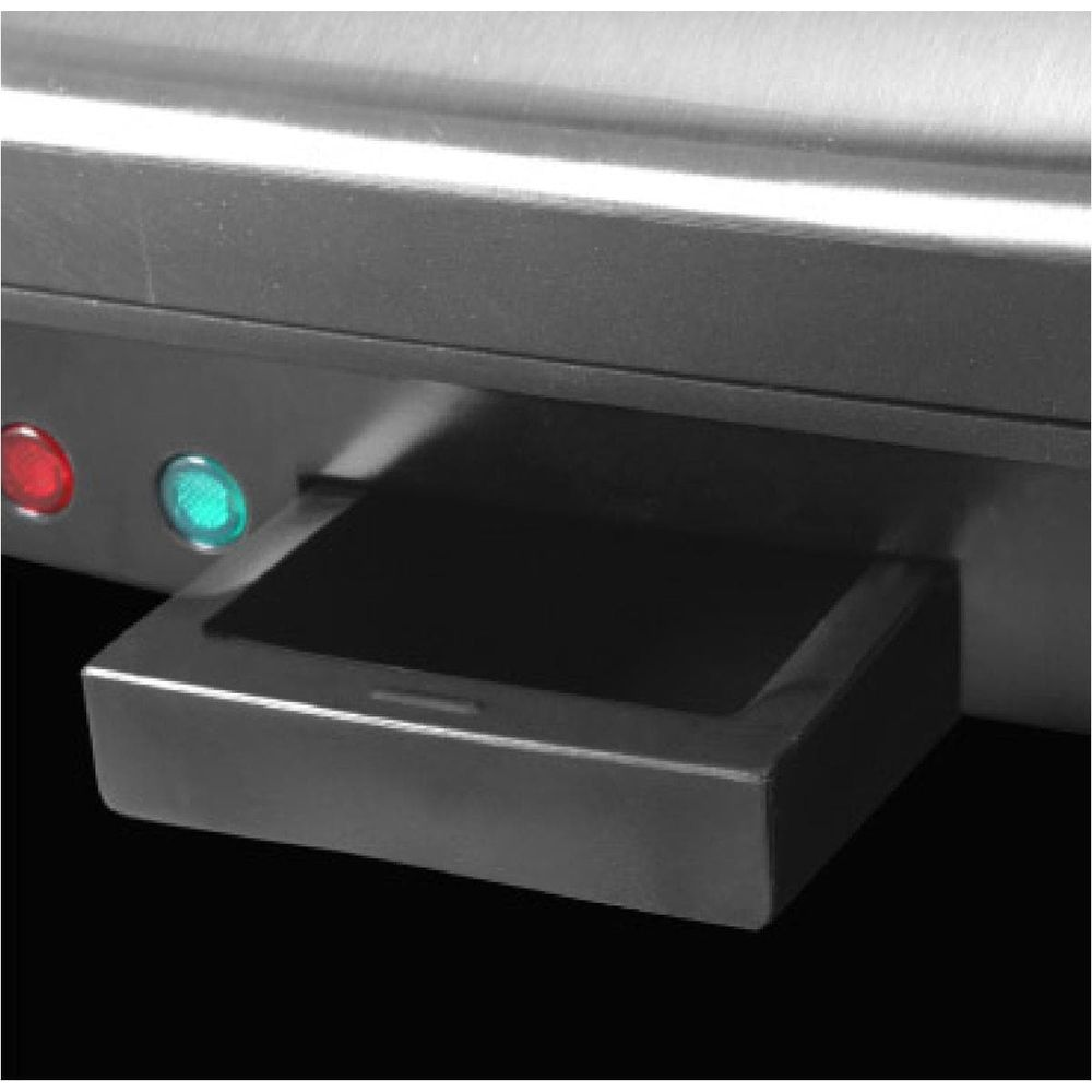 Zbliżenie metalowego urządzenia z czerwonym i zielonymi światłami wskaźnikowymi i wysuwaną szufladą.