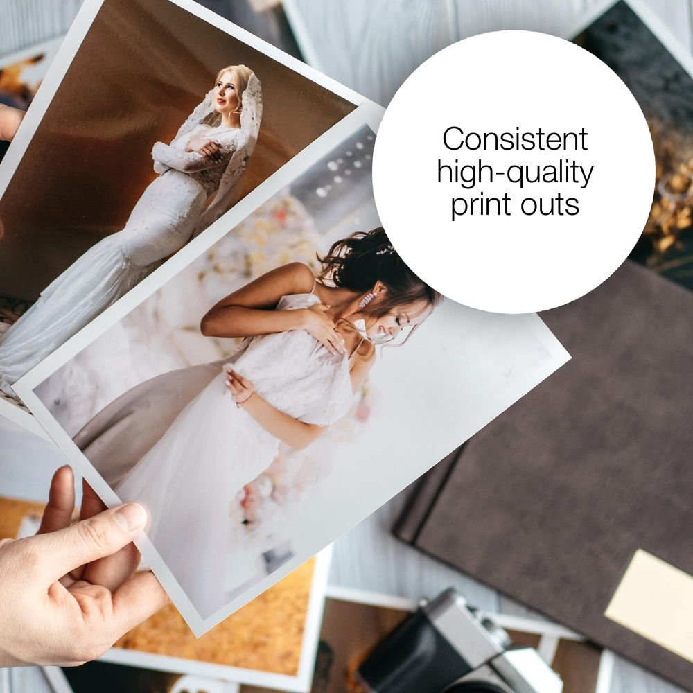 Dłonie trzymają zdjęcia ślubne. Panna młoda w białej sukni i welonie. Inna panna młoda w białej sukni.