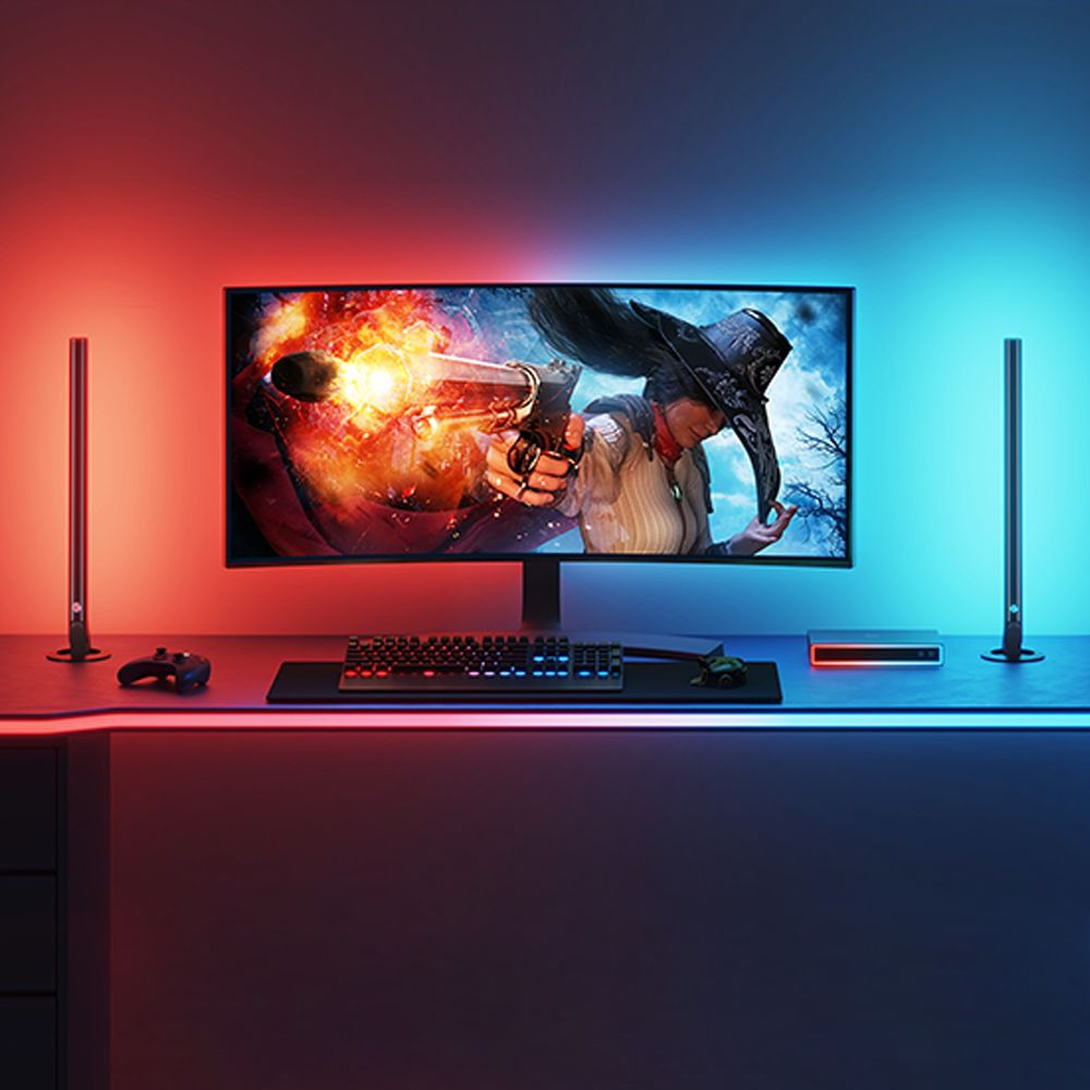 Ein Computermonitor zeigt ein Spiel. Links und rechts stehen Lichter. Tastatur und Controller liegen davor.