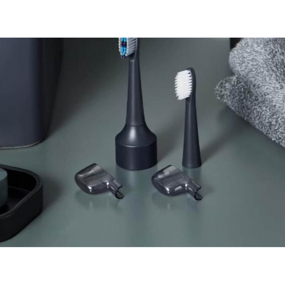 Una testina di spazzolino elettrico scuro con setole blu e copritestina.