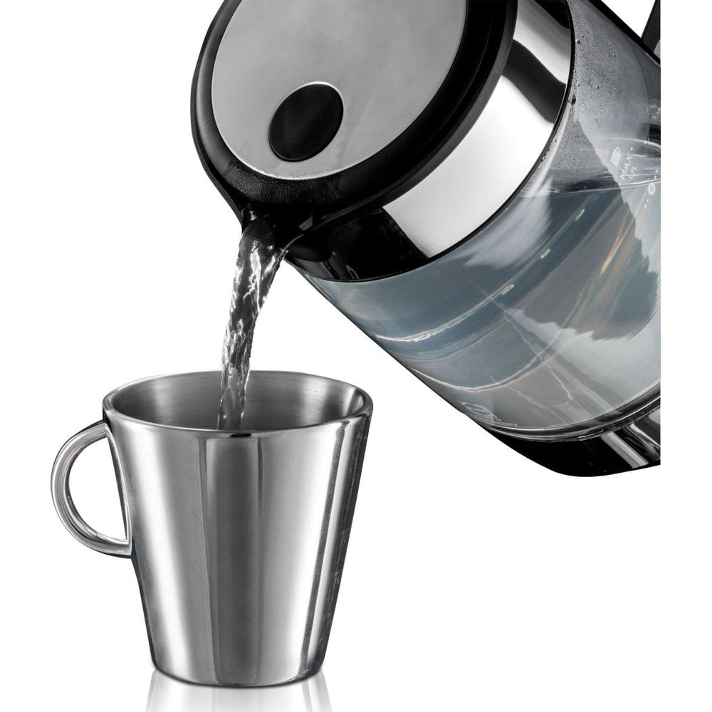 Wasser wird aus einem Wasserkocher in einen Metallbecher gegossen.