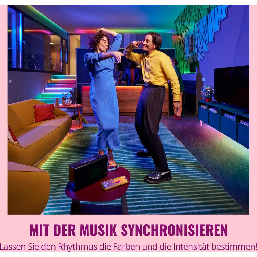A couple dances in a room with colorful lighting.