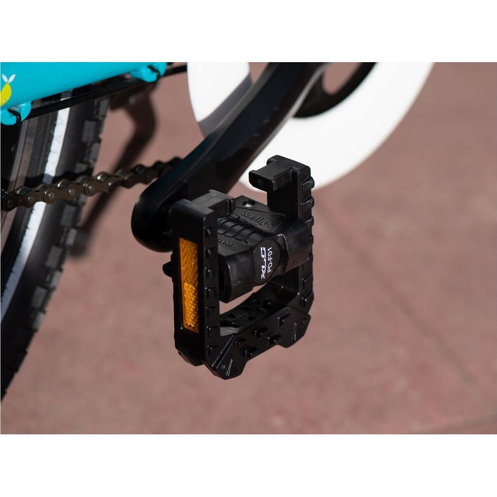 Czarny pedał rowerowy z odblaskiem na rowerze.