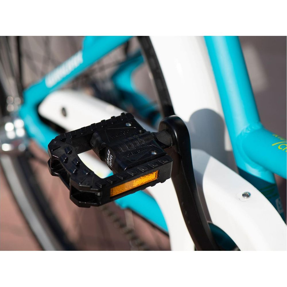 Czarny pedał rowerowy z odblaskiem, część turkusowego roweru.