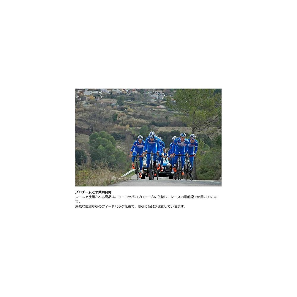 Kolarze w niebieskich strojach jadą drogą z drzewami i domami w tle.