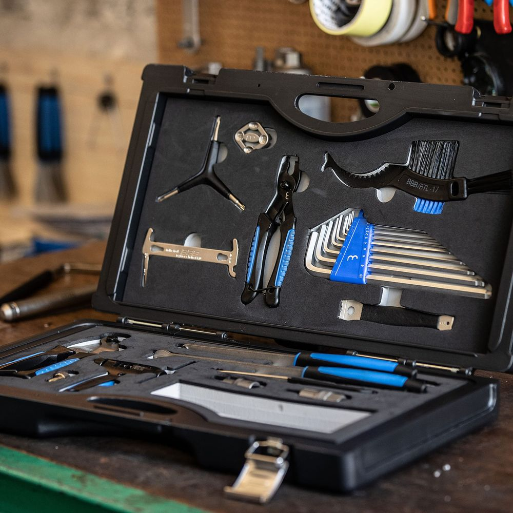 Otwarta skrzynka narzędziowa z różnymi narzędziami do naprawy rowerów, w tym szczypcami i kluczami imbusowymi.