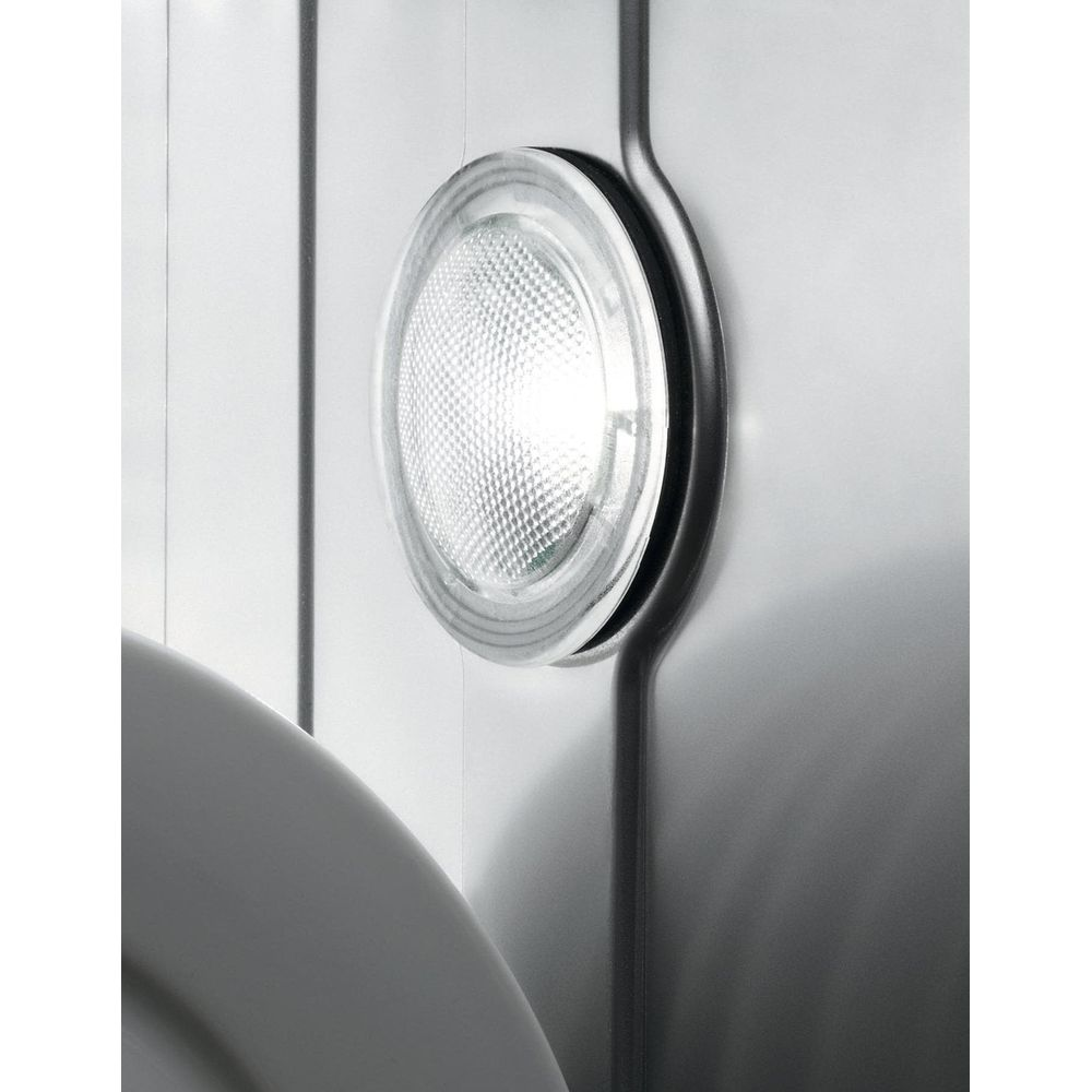Un spot encastré rond et lumineux avec un motif en treillis sur un mur blanc.
