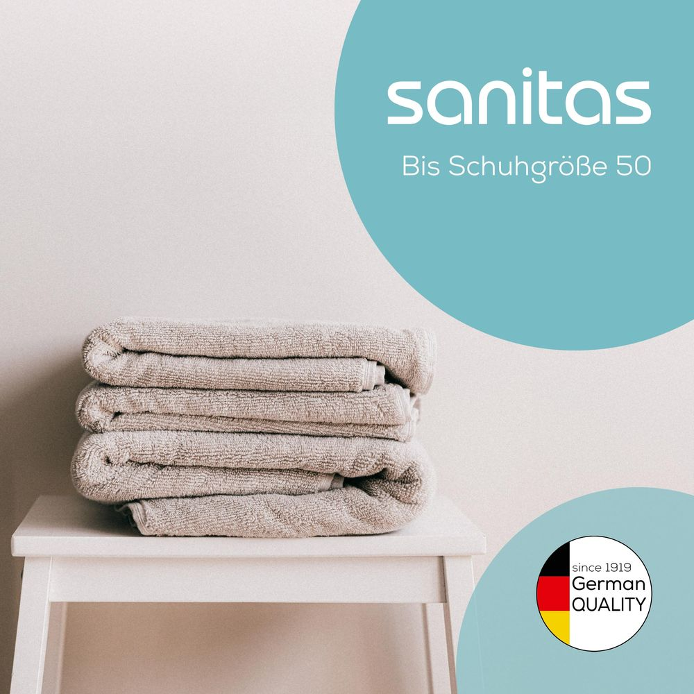 Pile de serviettes grises sur une table blanche, avec texte et logo.