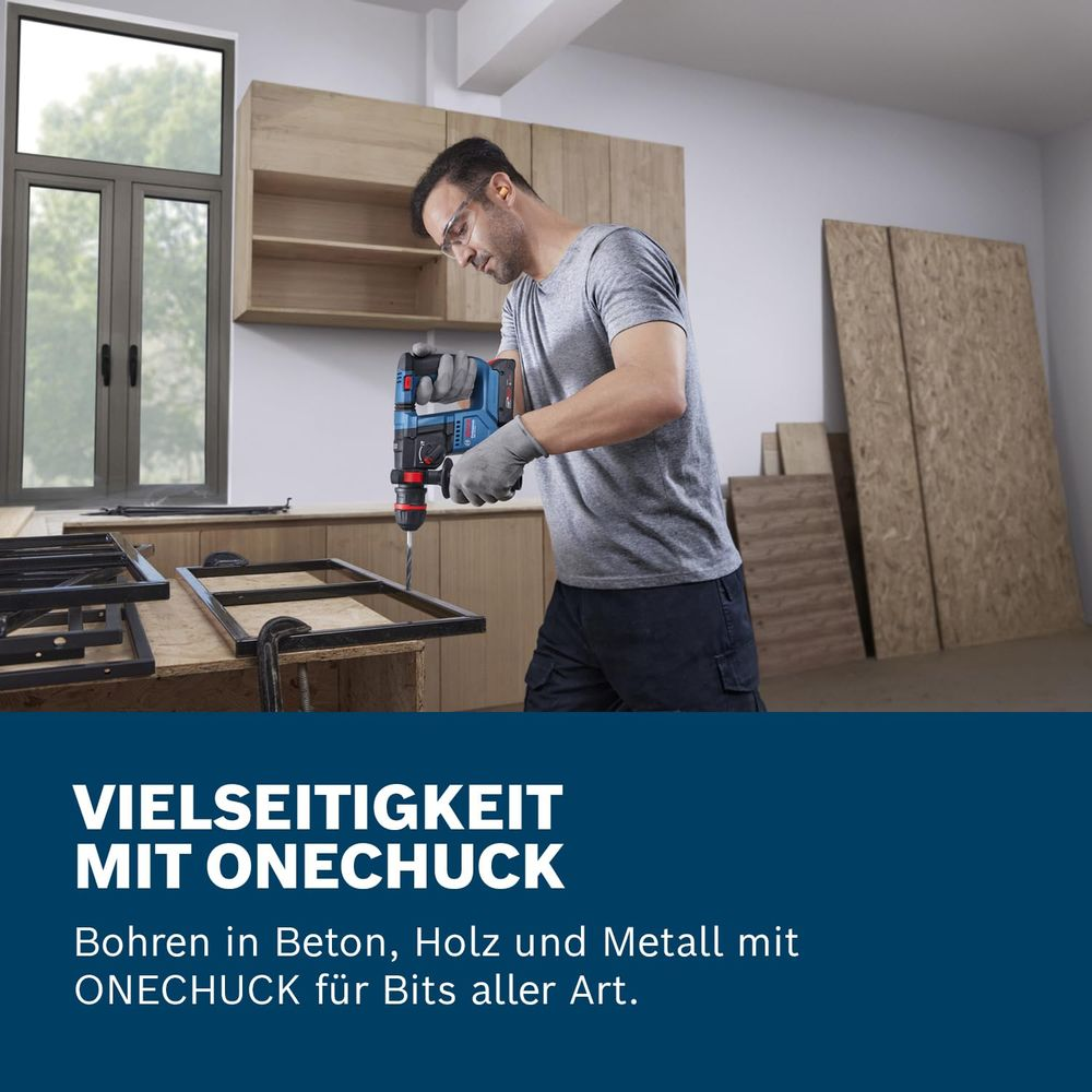 Mann bohrt mit blauem Bohrer in Metallrahmen. Holzschränke im Hintergrund.