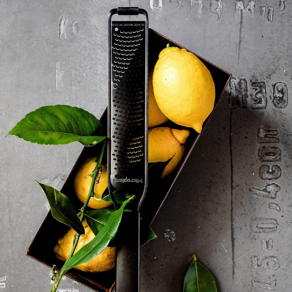 Gri zeminde bir kapta limonlu siyah rendenin.