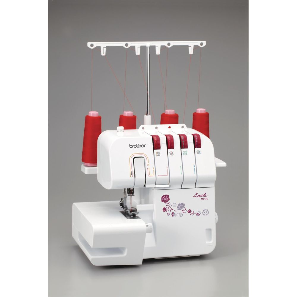 Biała maszyna do szycia z czerwonymi szpulami nici i wzorem kwiatowym.