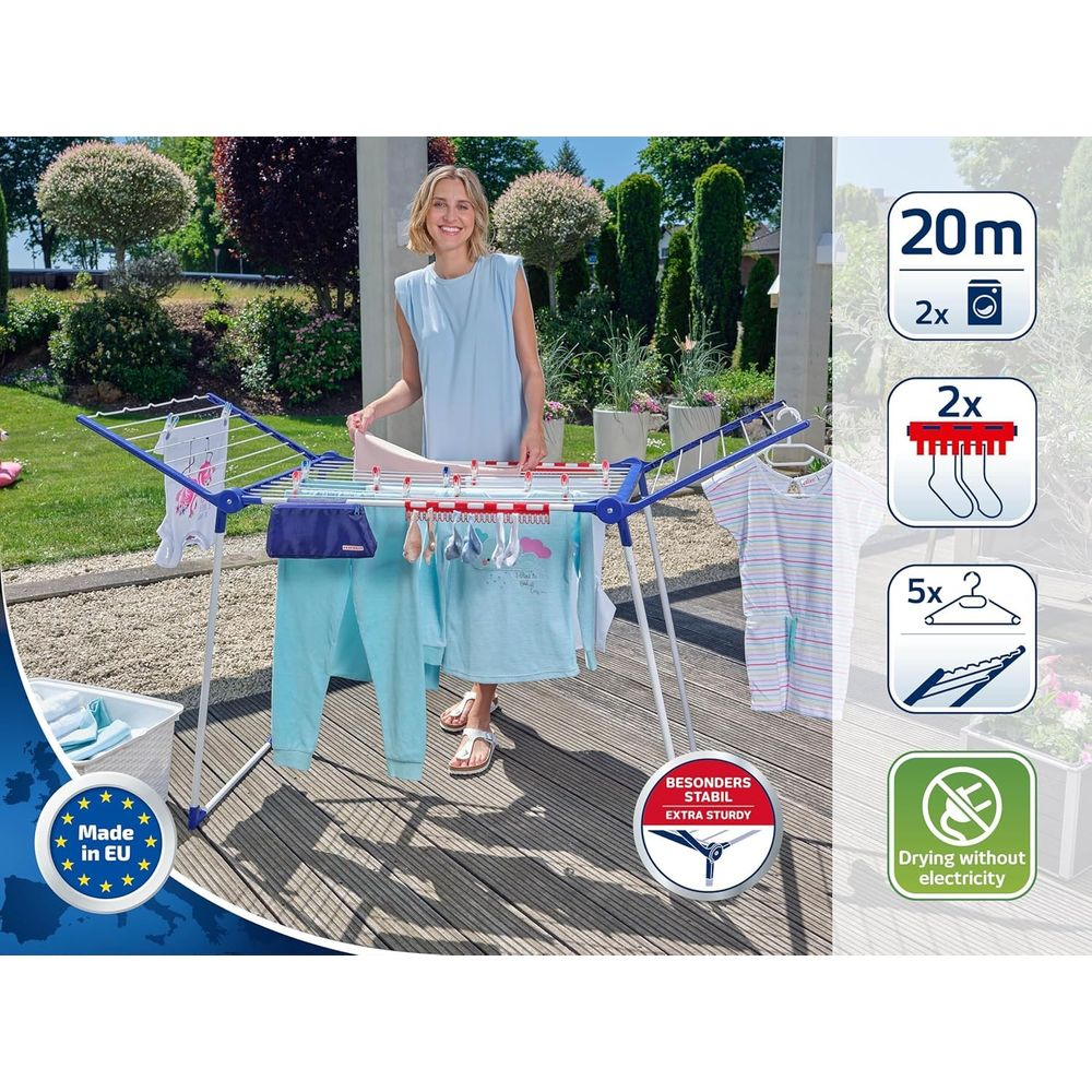 Frau steht neben einem Wäscheständer mit Kleidung im Garten.