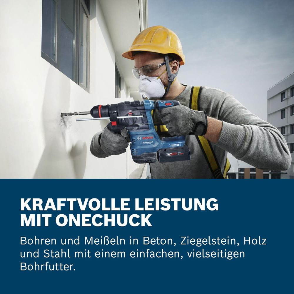 Mann mit Schutzhelm bohrt mit Bosch-Bohrmaschine in Wand.