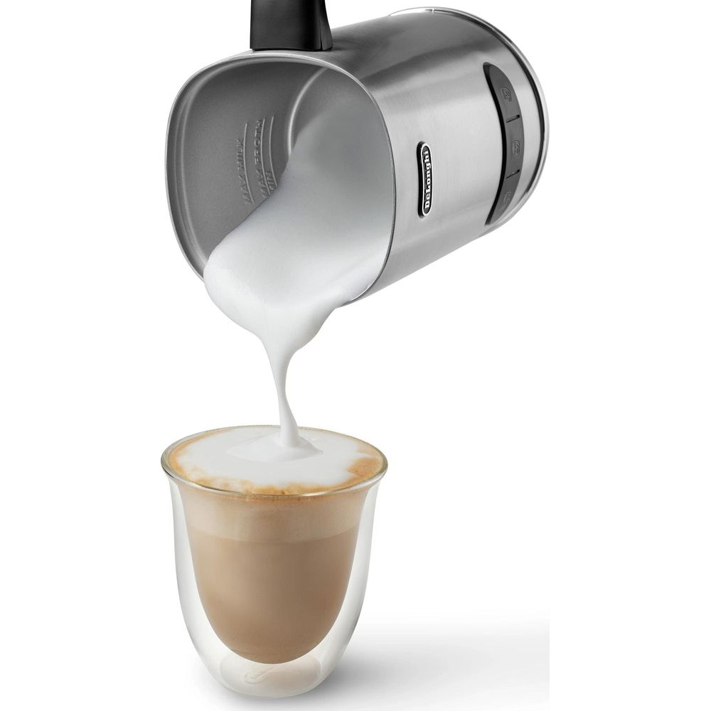 Ein Milchaufschäumer gießt Schaum in ein Glas Latte.