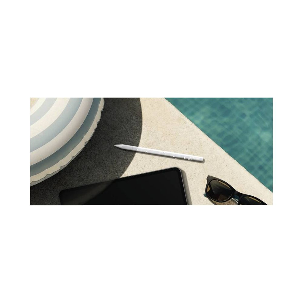 Tablet, rysik i okulary przeciwsłoneczne leżą na krawędzi basenu obok wody.