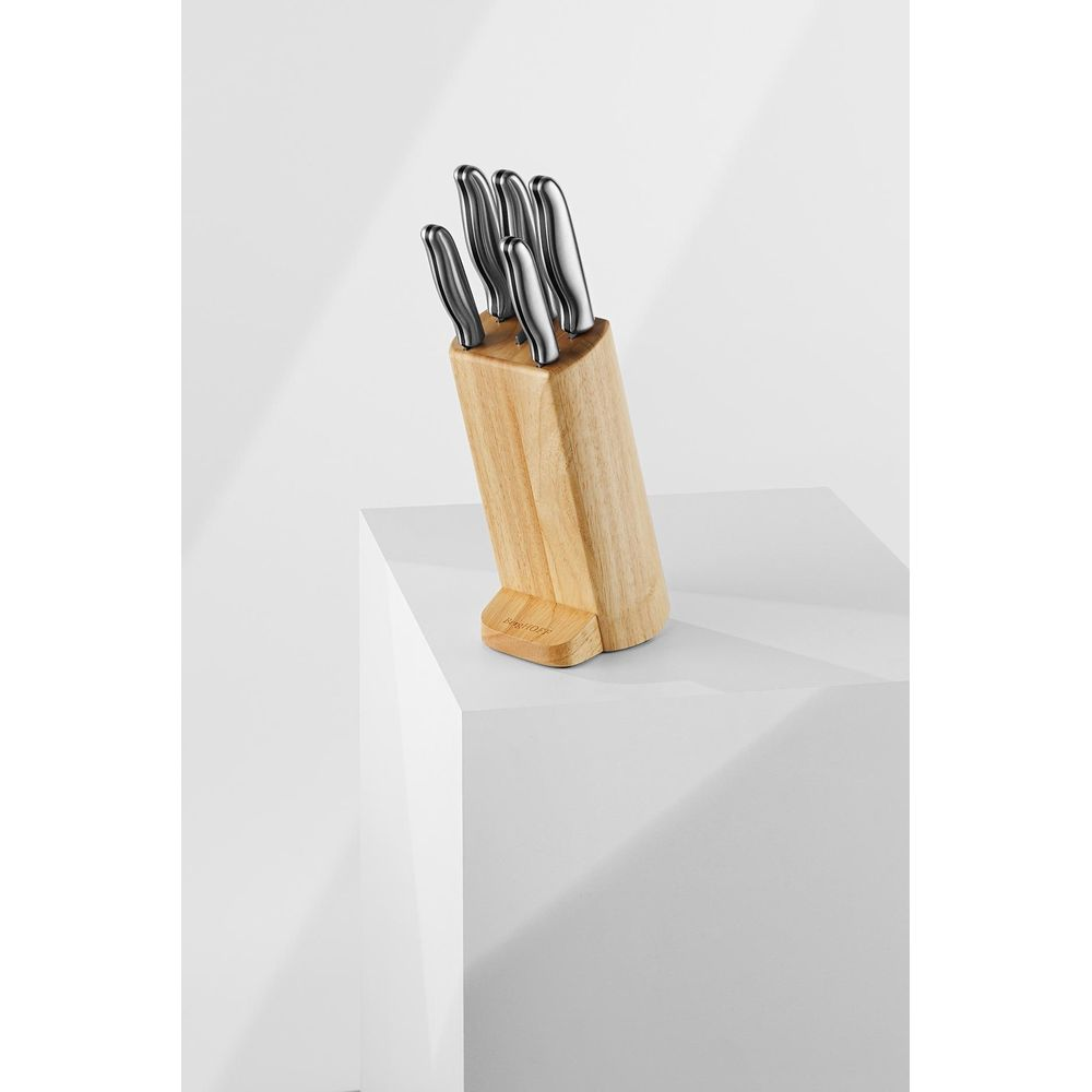 A wooden knife block with five knives resting on a white pedestal.