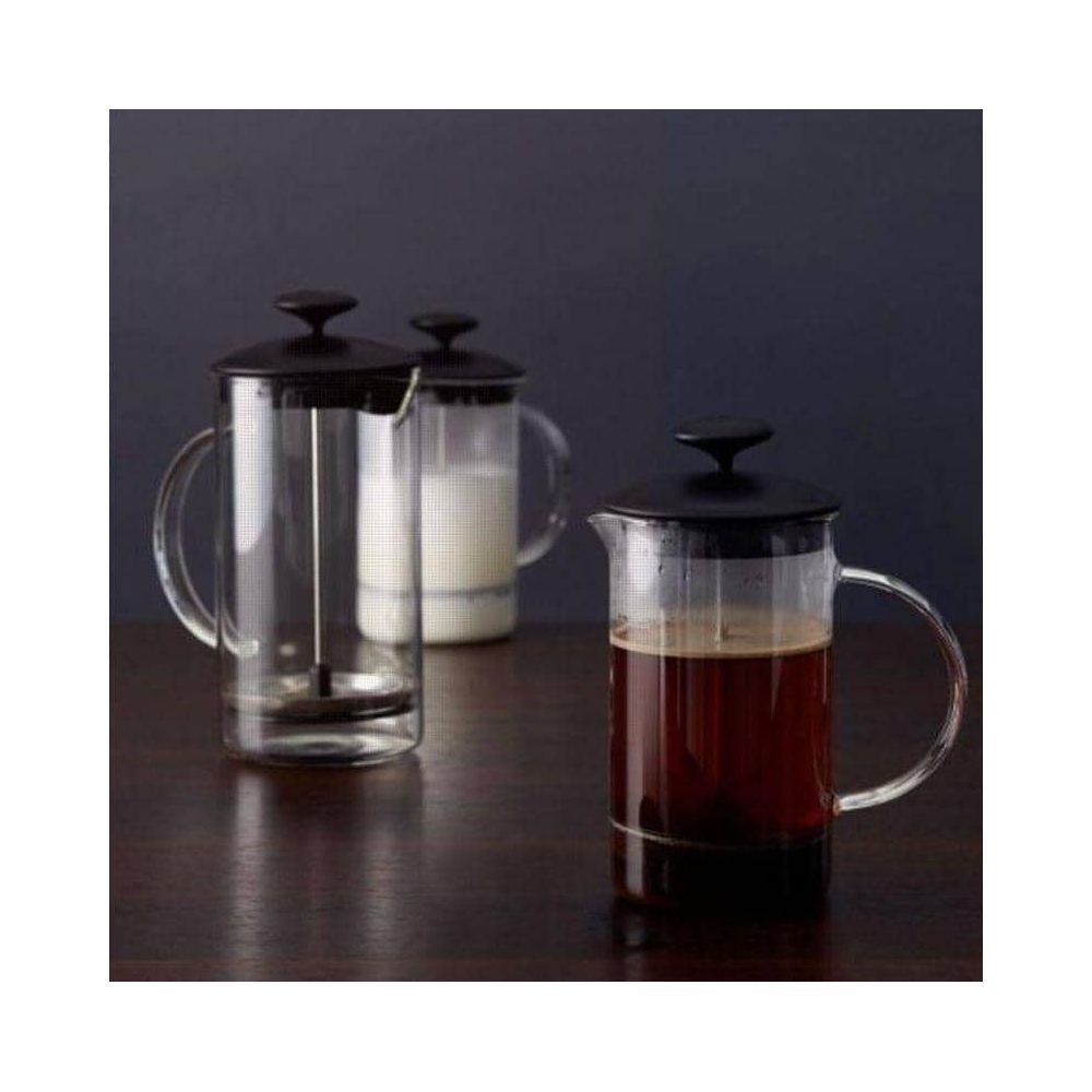 Drei Glas-French-Press-Kannen mit schwarzen Deckeln auf einem Holztisch.
