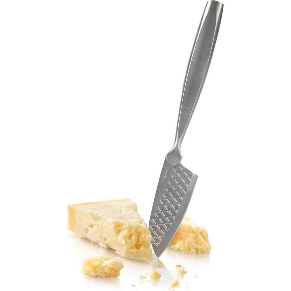 A cheese knife stands in a parmesan wedge on a white background.