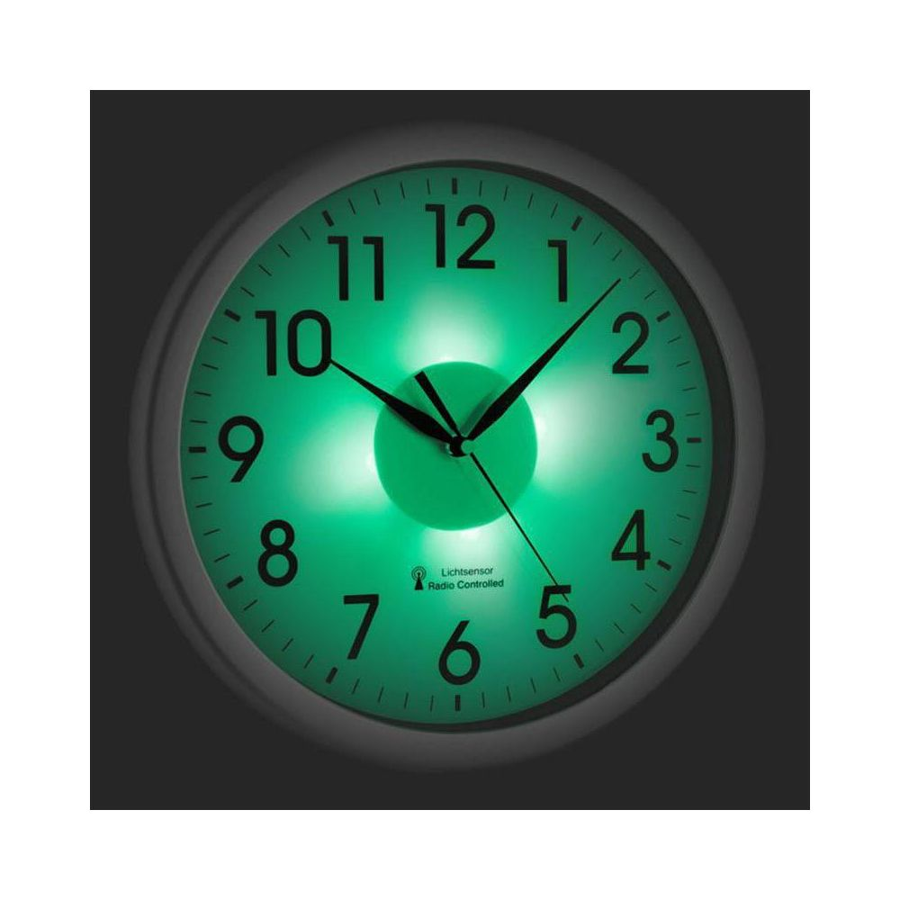 Eine grüne Wanduhr mit leuchtenden Ziffern und Zeigern, die die Zeit anzeigen.