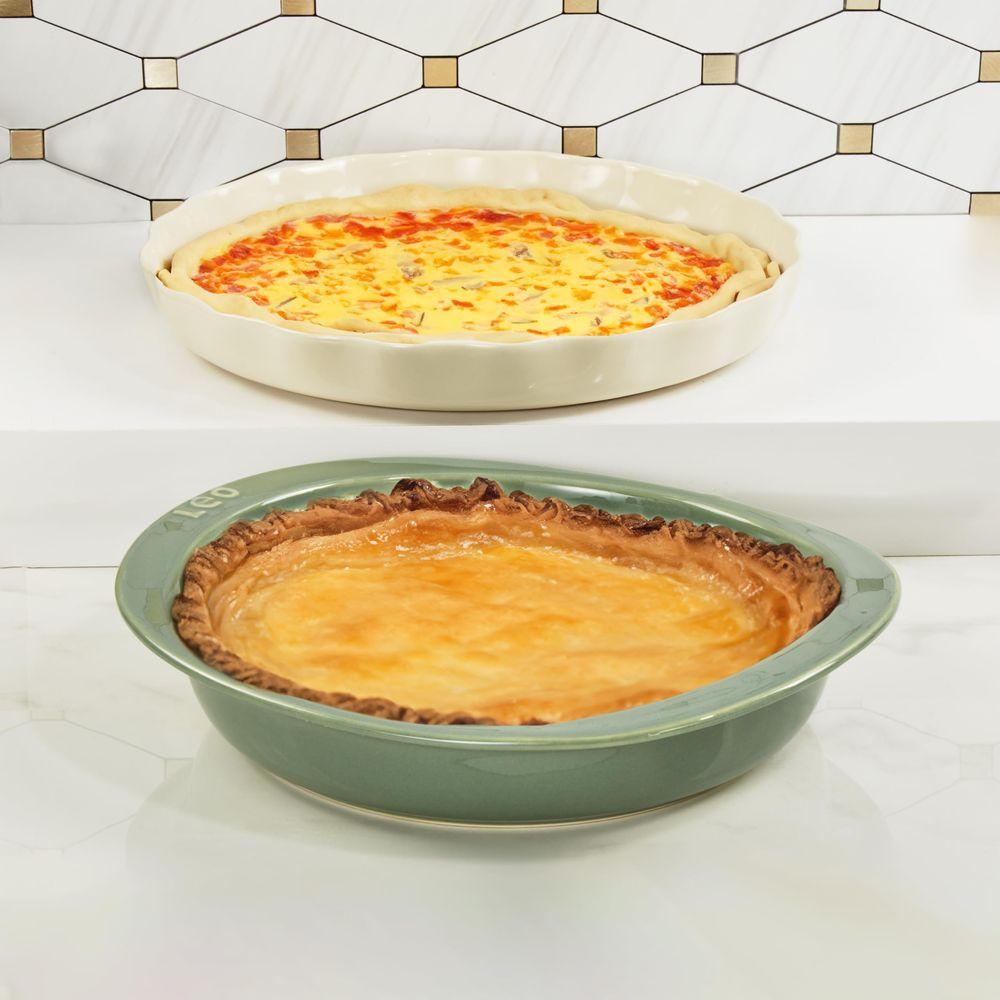 Zwei Quiches in Backformen, eine mit Tomaten und Käse, die andere goldbraun gebacken.