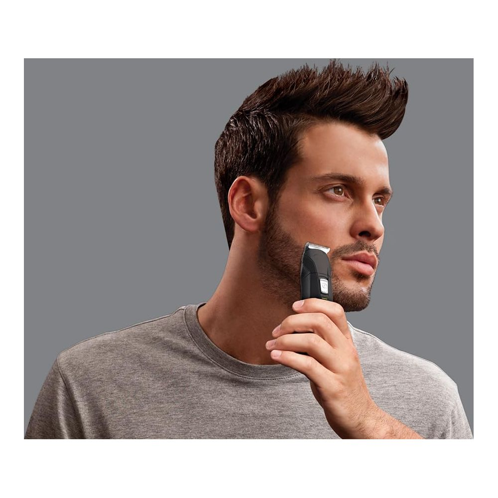Mężczyzna przycina brodę trymerem.