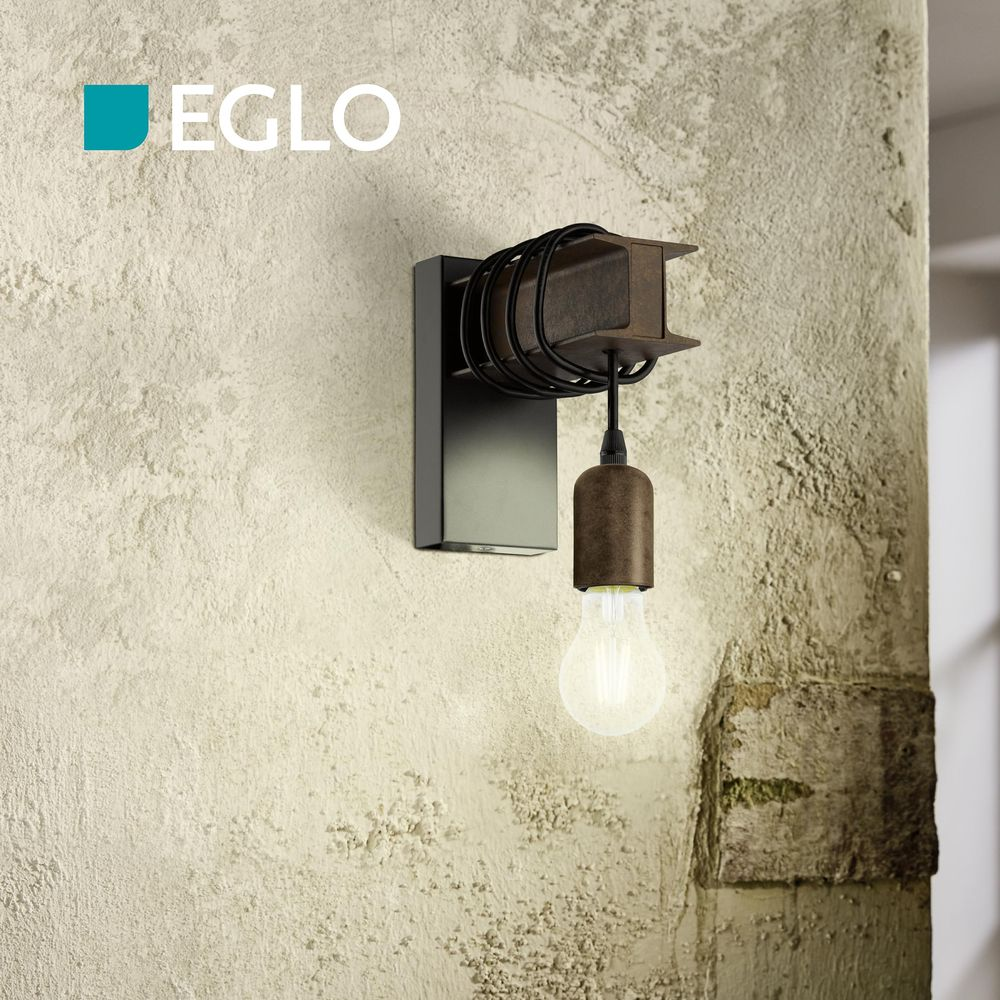 Lámpara de pared industrial con detalle de viga I, carcasa negra y bombilla.