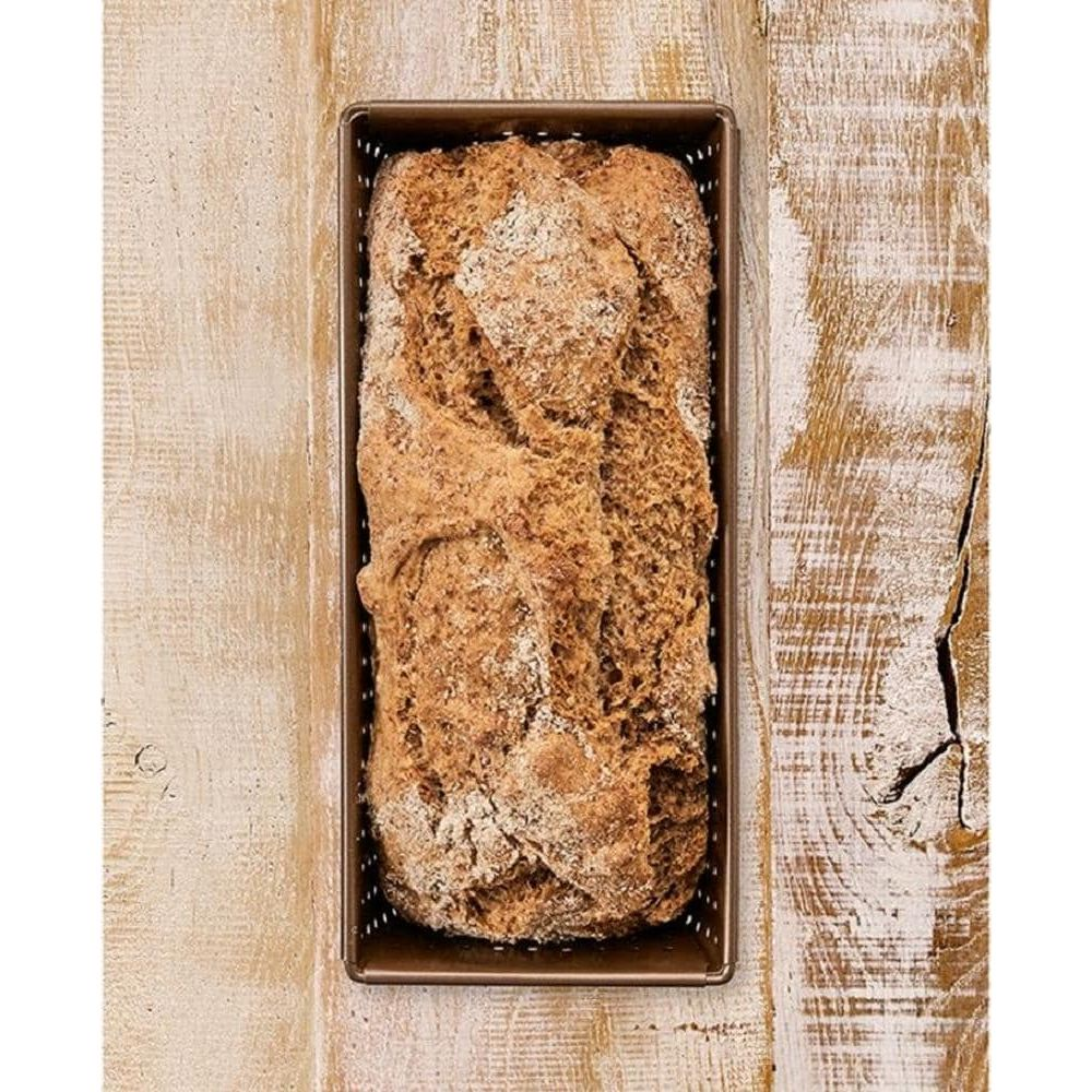 Ein goldbraunes Brot in einer rechteckigen Form auf einem Holztisch.