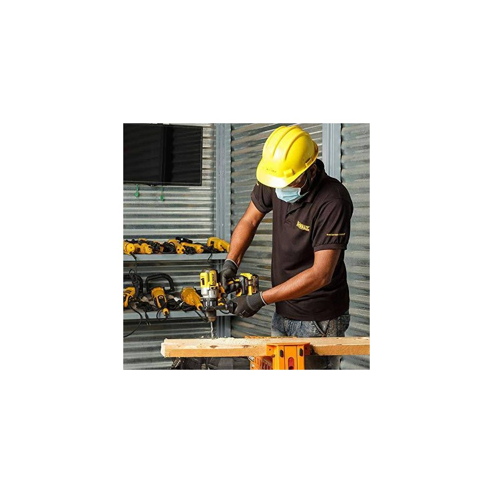 Ein Mann mit gelbem Helm bohrt in Holz. Werkzeuge sind im Regal.