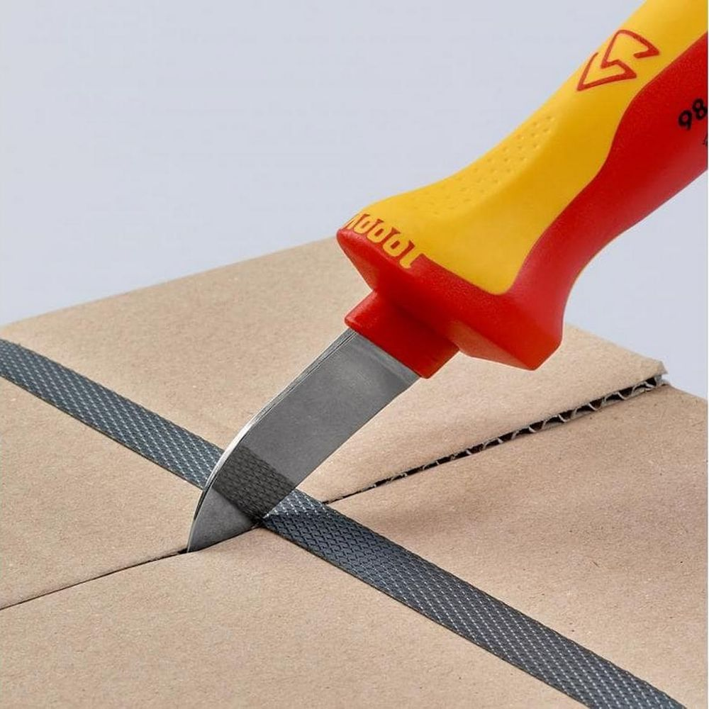 Ein Messer mit gelb-rotem Griff schneidet ein Paketband auf einem Karton.