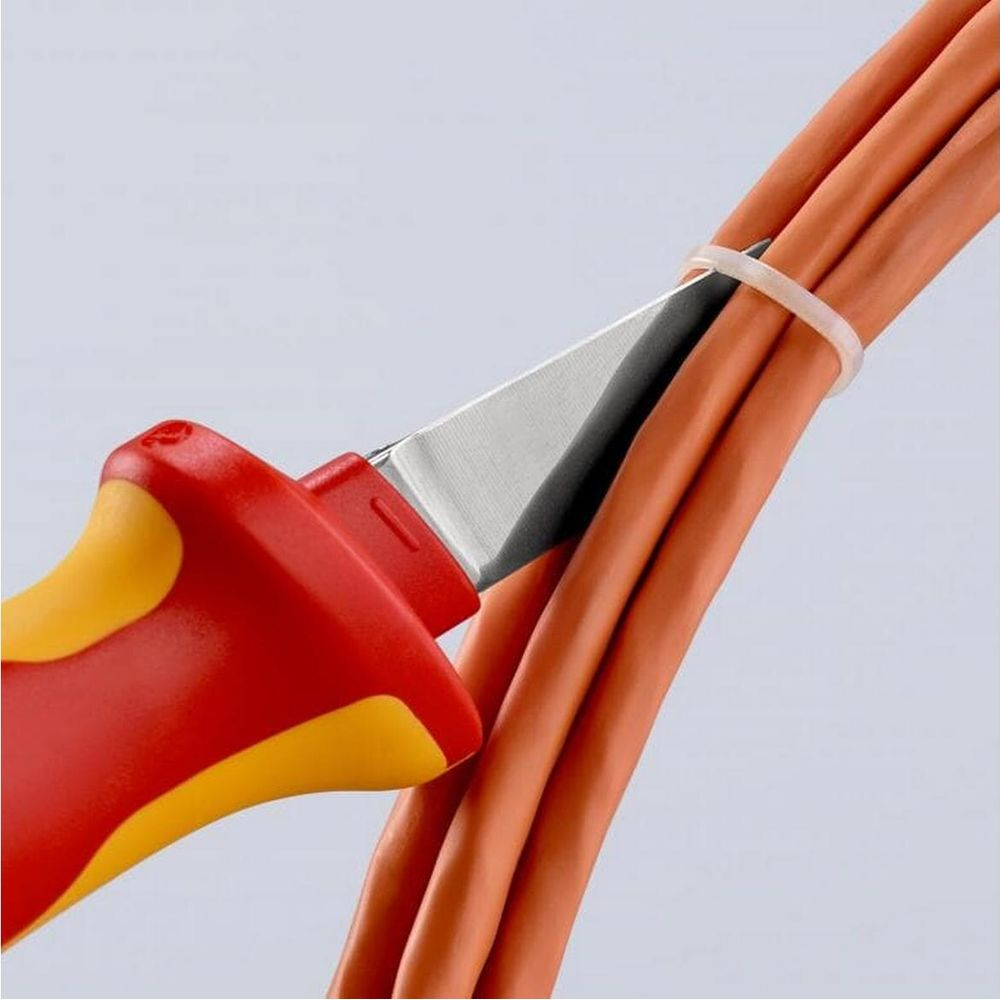 Ein Seitenschneider mit roten und gelben Griffen schneidet ein Paket orangefarbener Kabel.