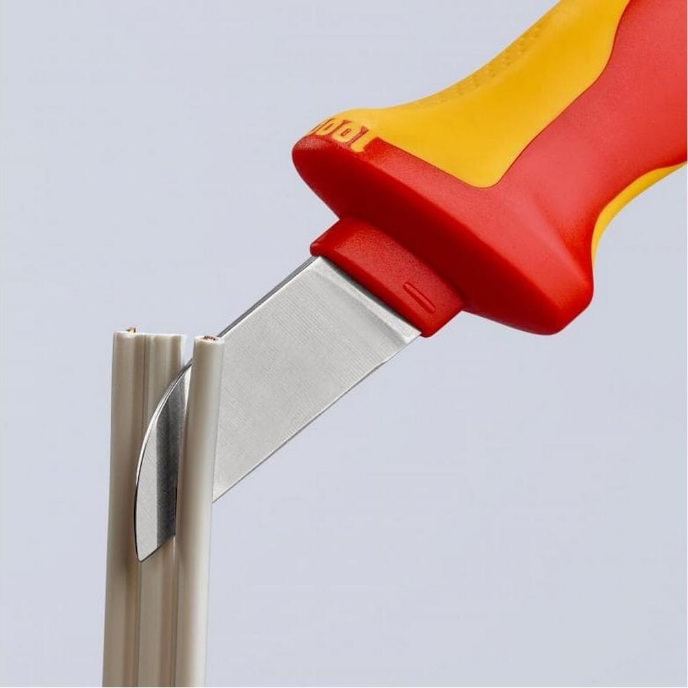 Ein Kabelmesser mit rotem und gelbem Griff schneidet Kabelisolierung.