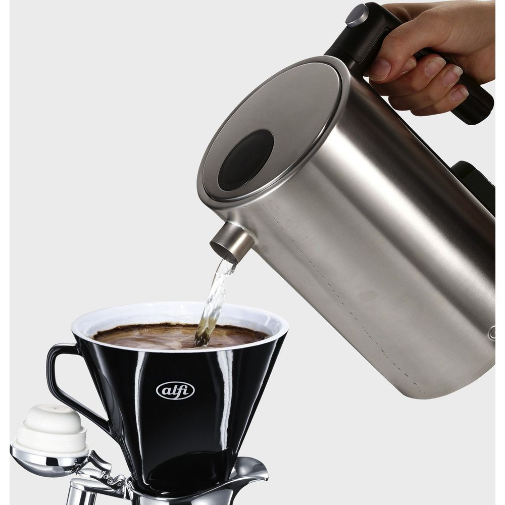 Wasser wird aus einem silbernen Wasserkocher in eine schwarze Kaffeetasse gegossen.