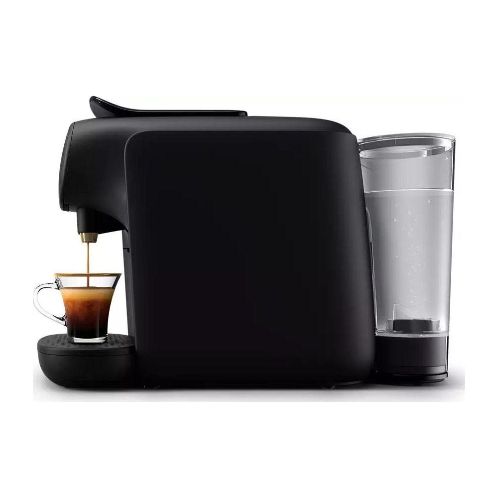 Une machine à café noire avec un verre d'eau et de l'espresso coulant dans une tasse.