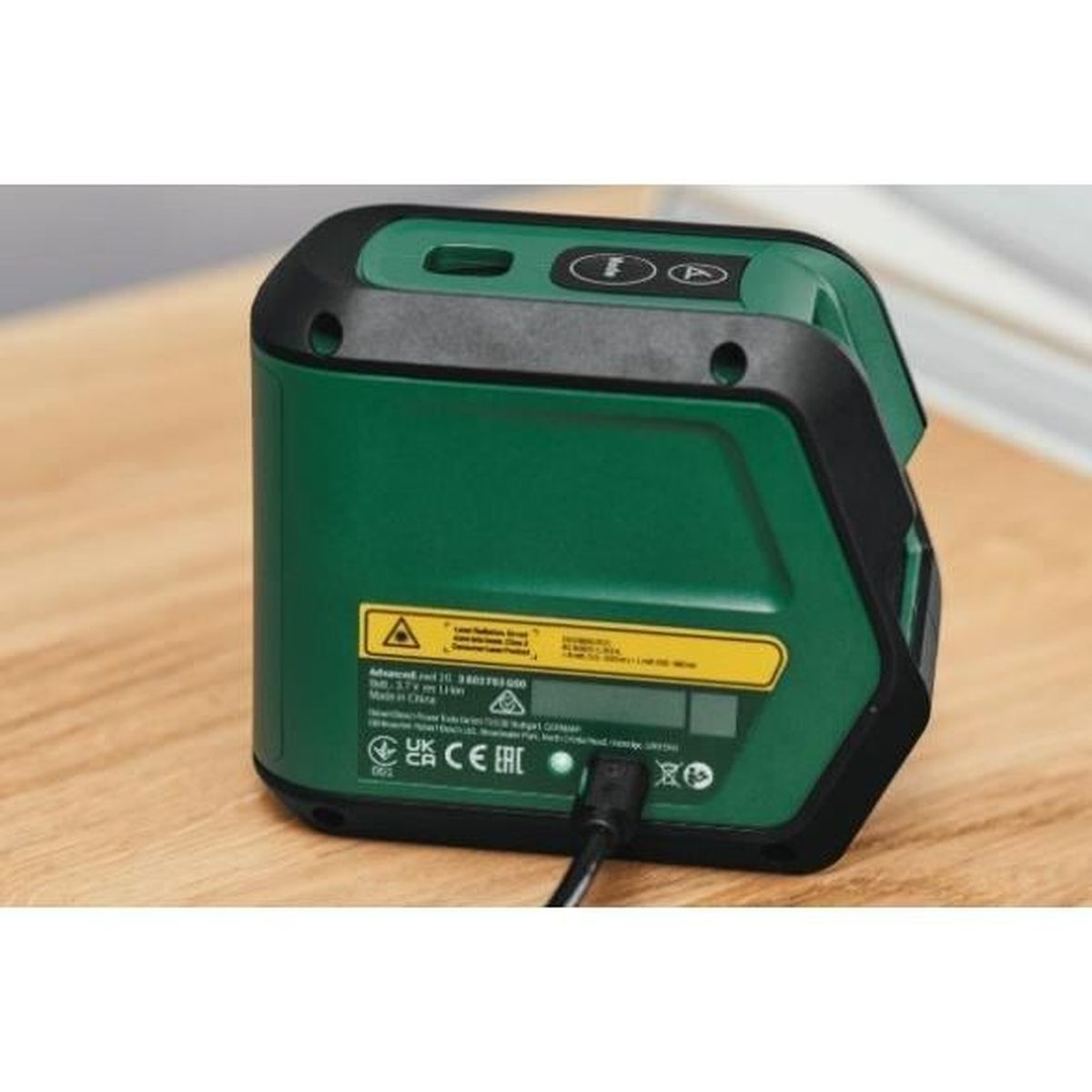 Dispositivo livella laser verde con accenti neri su tavolo legno.