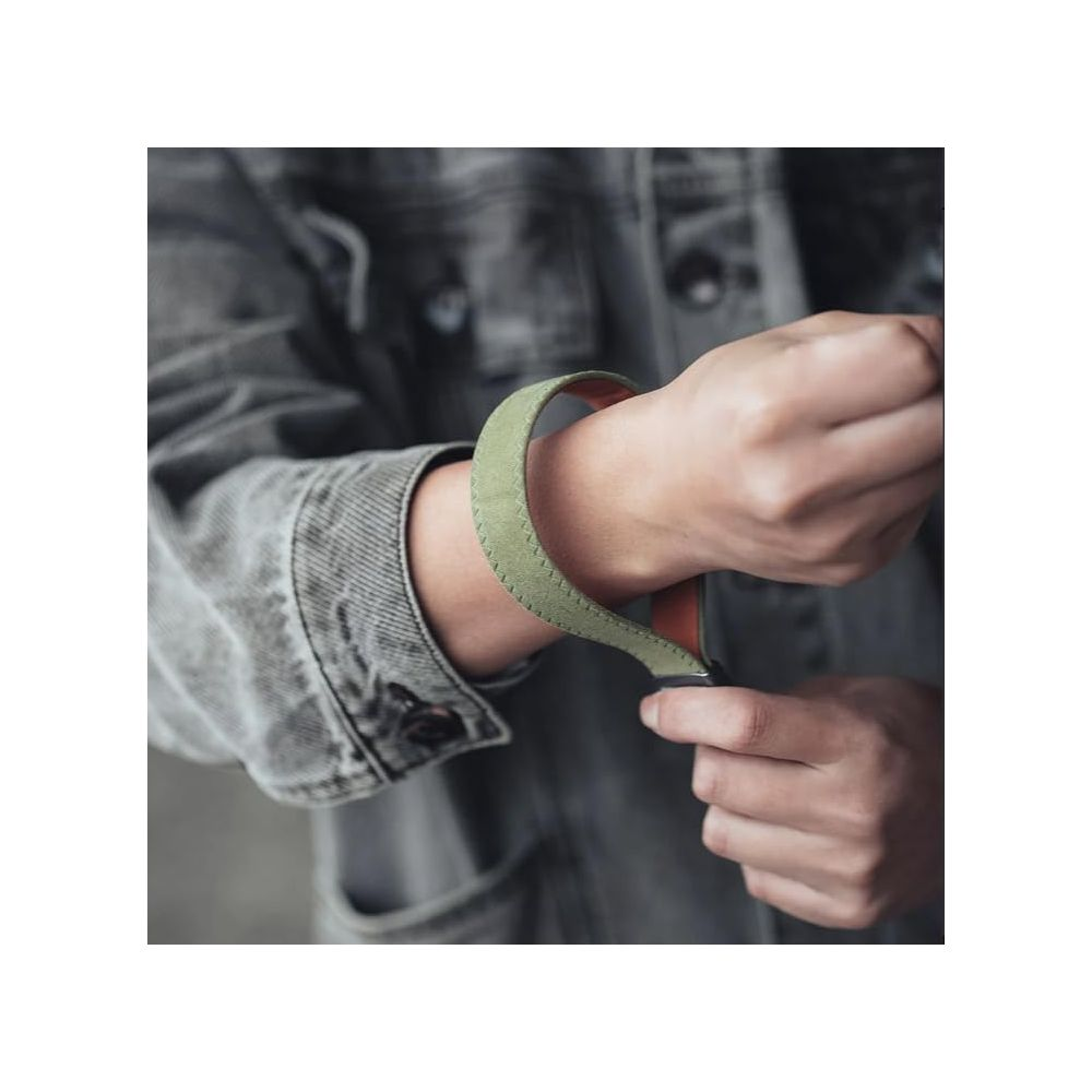 Osoba w dżinsowej kurtce zapina zieloną bransoletkę na nadgarstku.